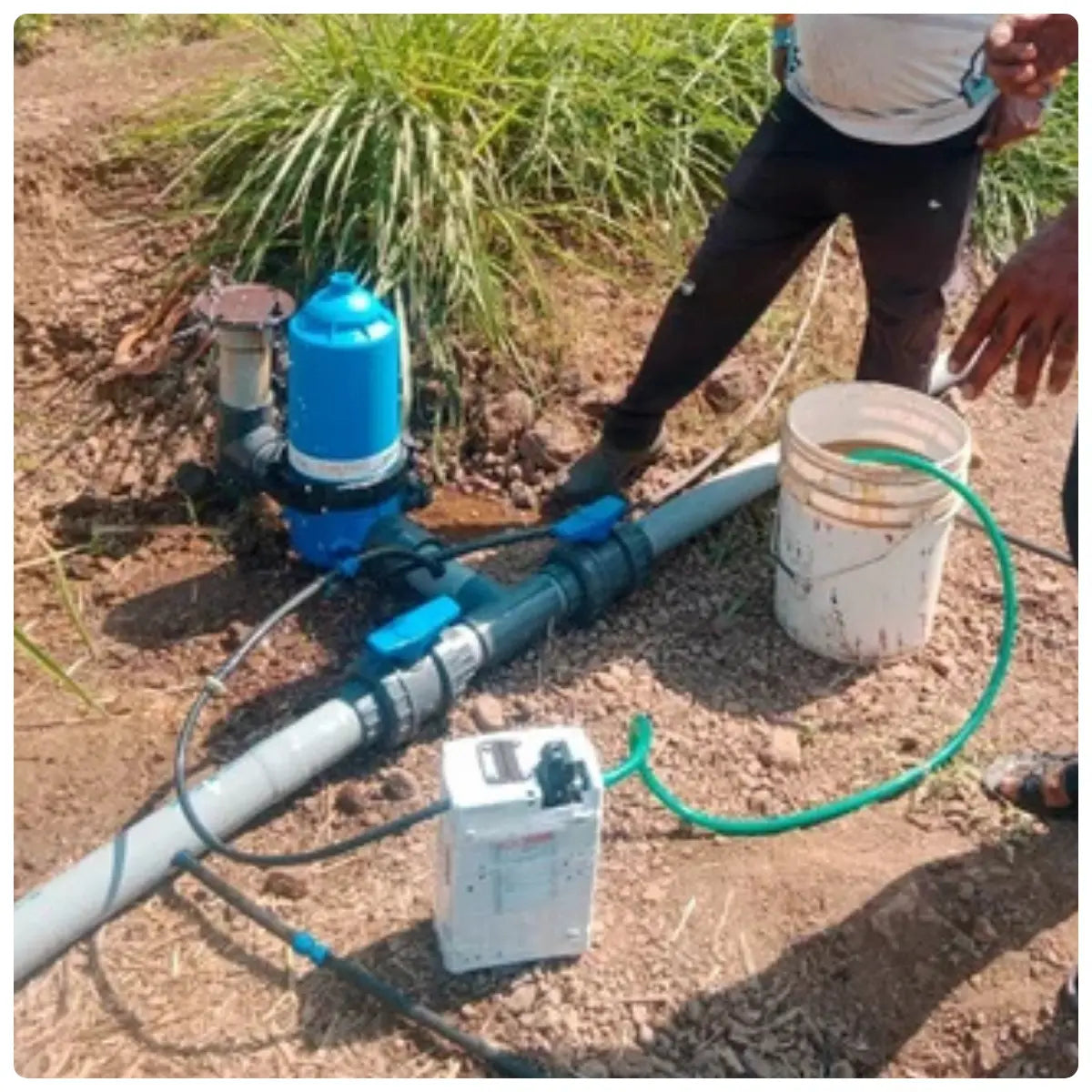 Person working with a water injector pump system outdoors