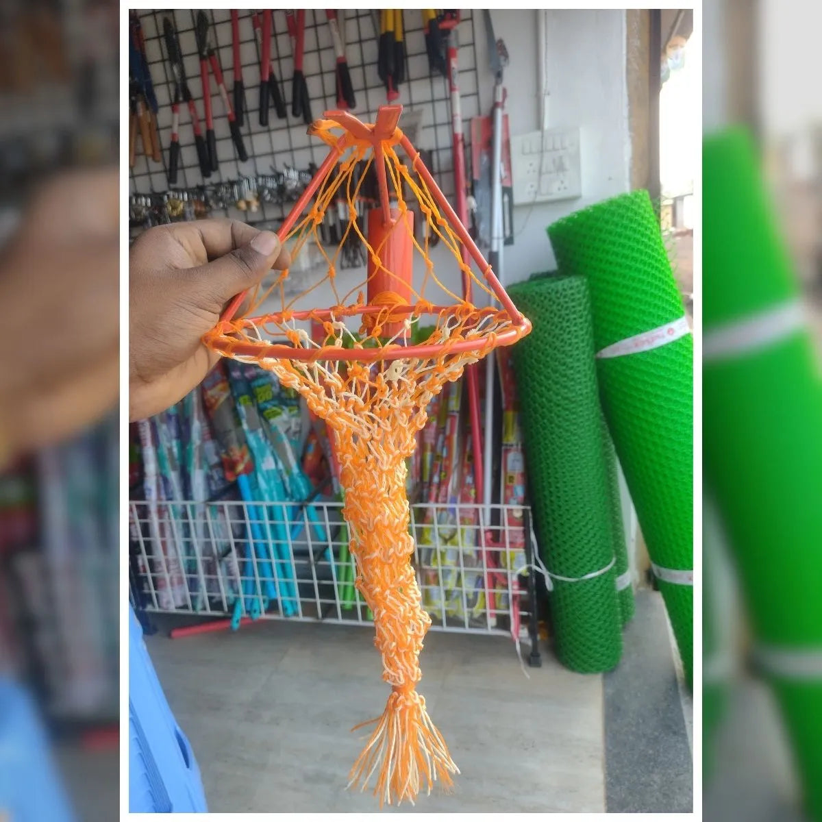 Orange net held by a hand with a shop background