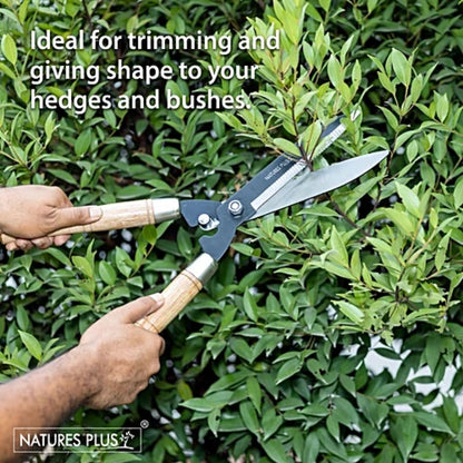 Person using garden shears to trim hedges with text 'Ideal for trimming and giving shape to your hedges and bushes' and 'Natures Plus' logo.