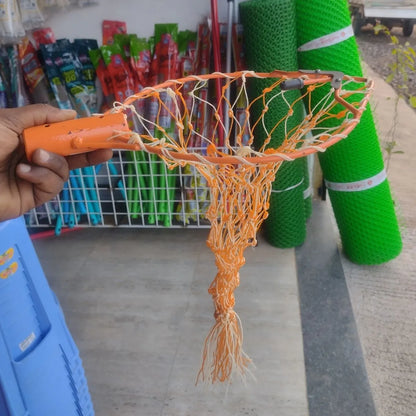 mango plucker net held by a hand with a store and green mesh rolls in the background